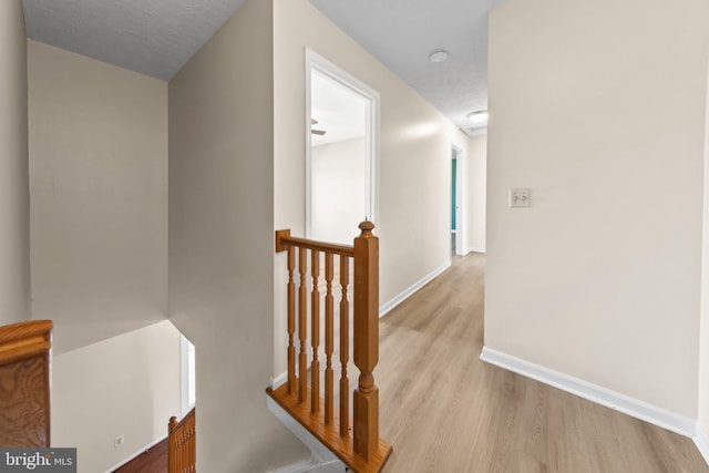 hall featuring a textured ceiling and light wood-type flooring