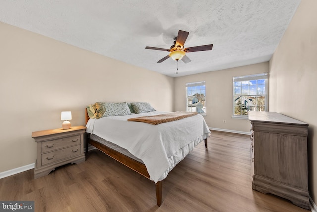 bedroom featuring ceiling fan, dark wood-type flooring, and a textured ceiling