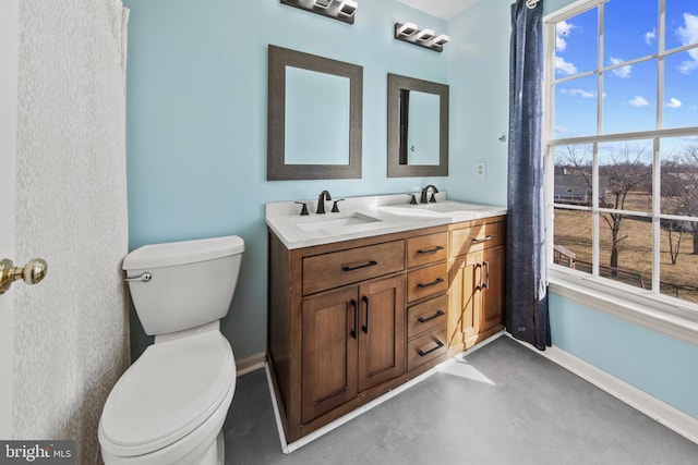 bathroom featuring vanity, concrete floors, and toilet