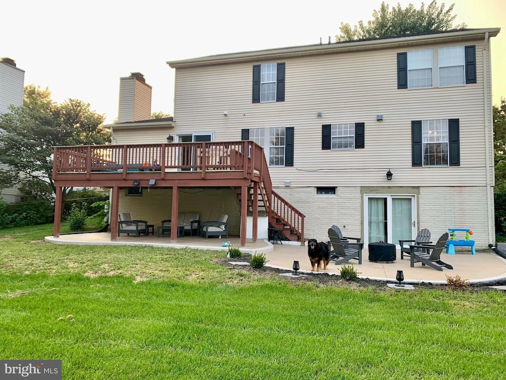 rear view of property with a patio area, a lawn, and a deck