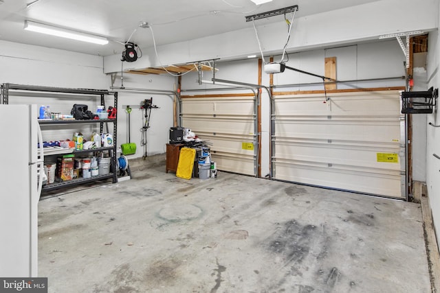 garage with a garage door opener and white fridge