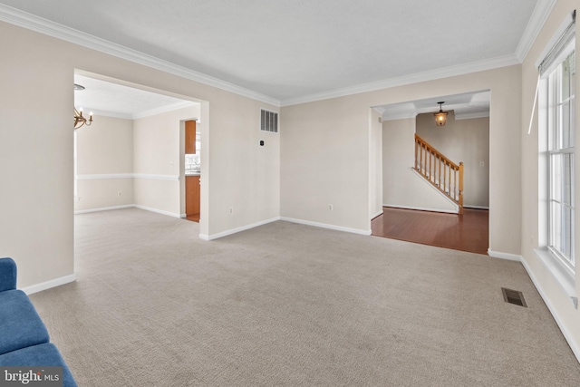 unfurnished living room featuring crown molding, plenty of natural light, an inviting chandelier, and carpet