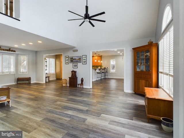 living room with ceiling fan, plenty of natural light, and dark hardwood / wood-style floors