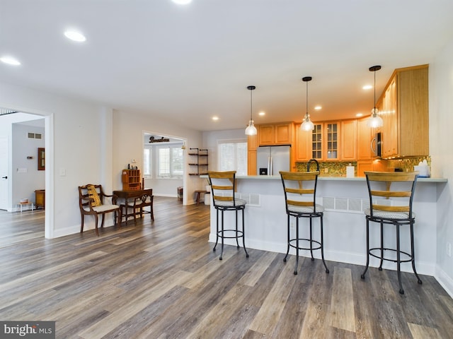 kitchen featuring decorative light fixtures, dark hardwood / wood-style flooring, tasteful backsplash, and stainless steel appliances