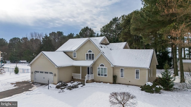 view of front of home featuring driveway, an attached garage, and fence