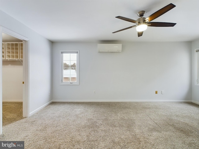 unfurnished room featuring carpet floors, ceiling fan, and a wall unit AC