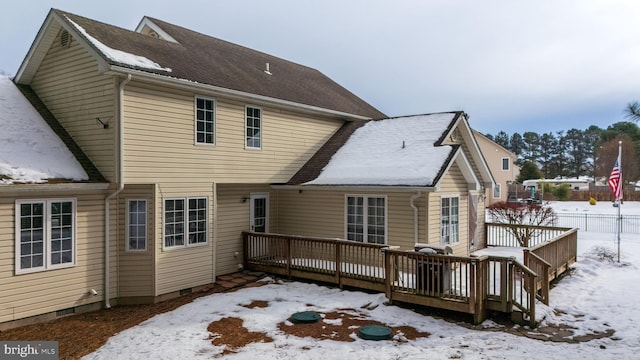 snow covered back of property featuring a deck