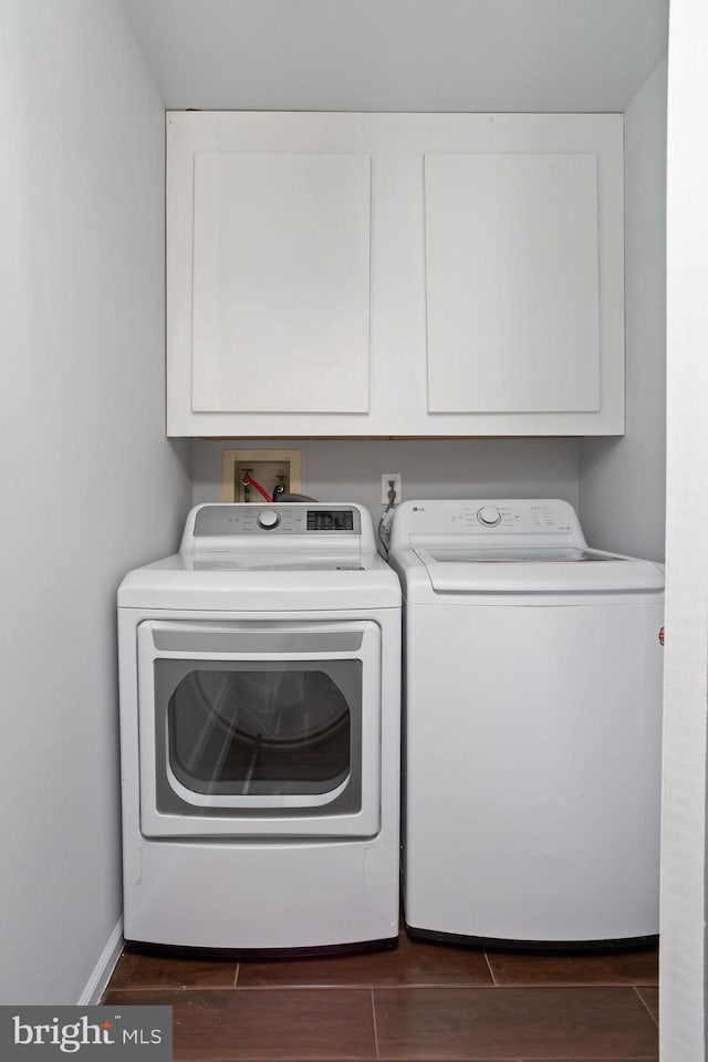 washroom with washer and clothes dryer and cabinets