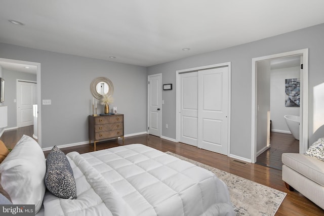 bedroom featuring a closet, dark hardwood / wood-style floors, and ensuite bath