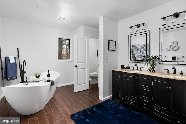 bathroom with toilet, a tub, and vanity