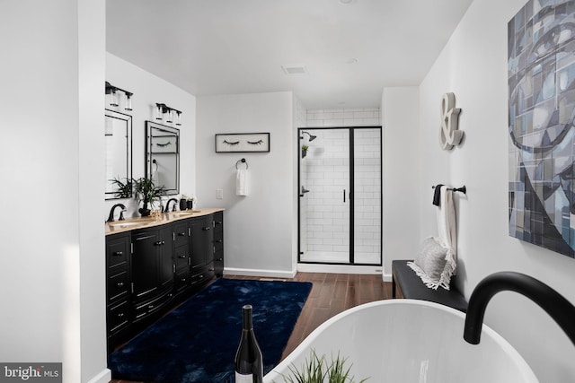 bathroom with hardwood / wood-style flooring, vanity, and independent shower and bath