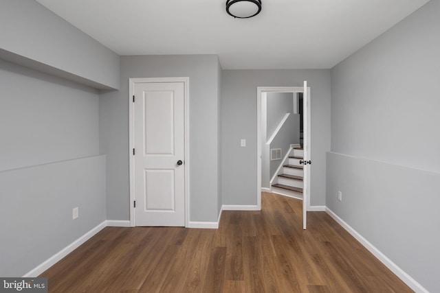 basement with dark hardwood / wood-style floors