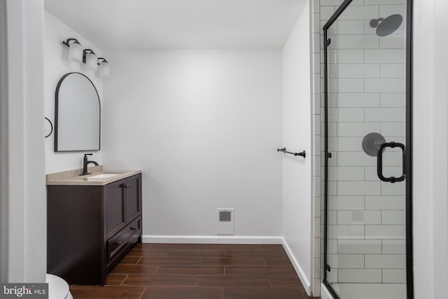 bathroom with walk in shower, vanity, and toilet