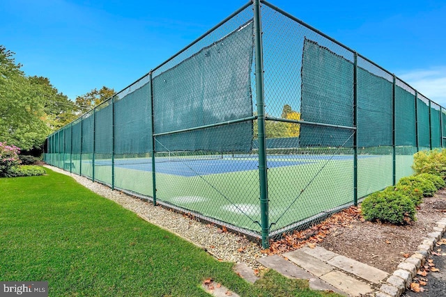 view of tennis court with a yard