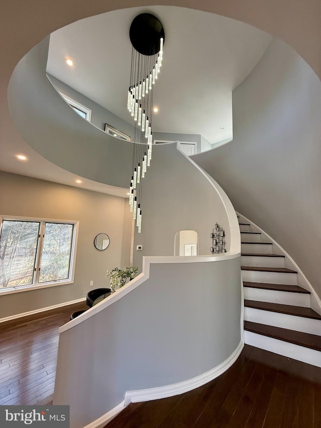 staircase with a high ceiling and hardwood / wood-style flooring