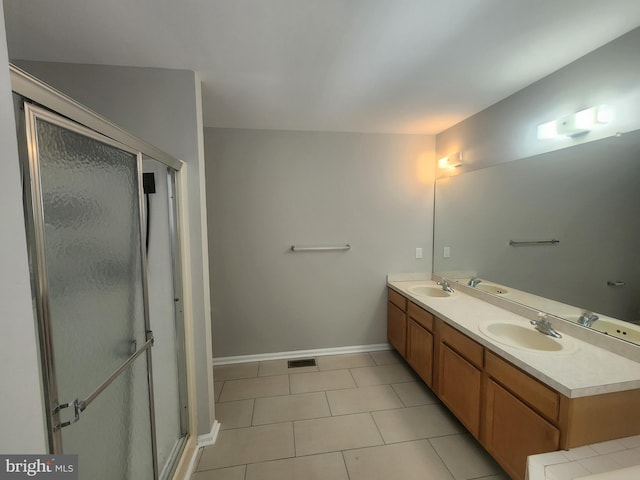 bathroom featuring tile patterned floors, vanity, and a shower with shower door