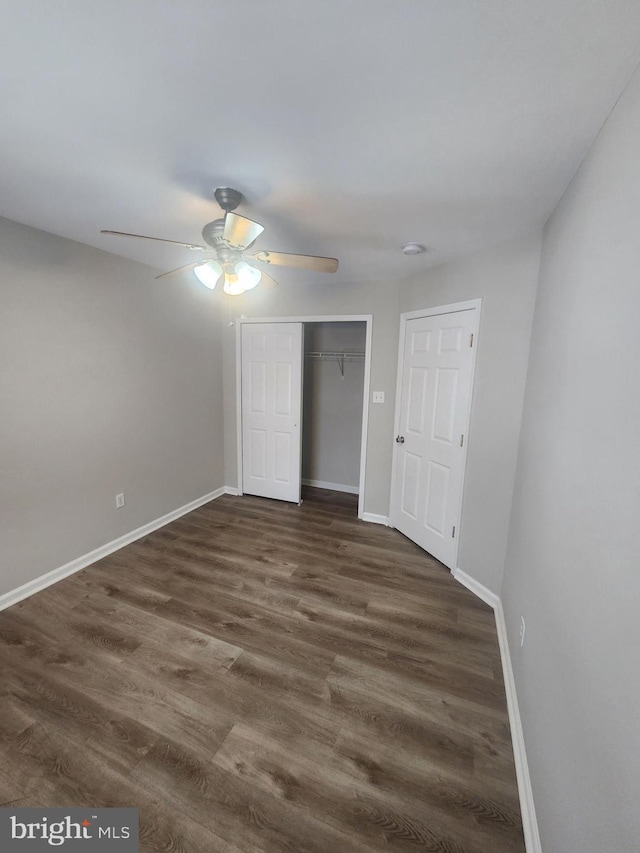 unfurnished bedroom featuring a closet, ceiling fan, and dark wood-type flooring