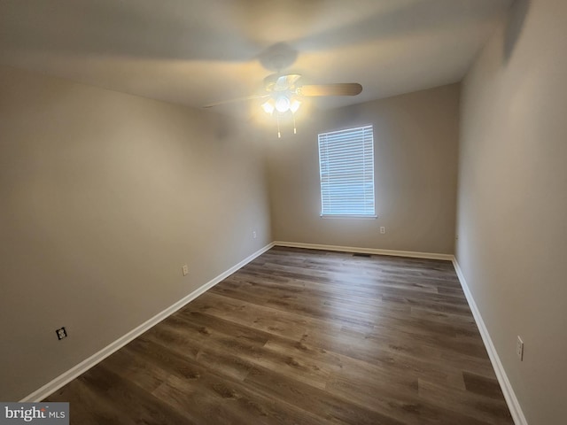 empty room featuring ceiling fan and dark hardwood / wood-style flooring