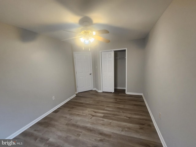 unfurnished bedroom featuring ceiling fan, dark hardwood / wood-style flooring, and a closet