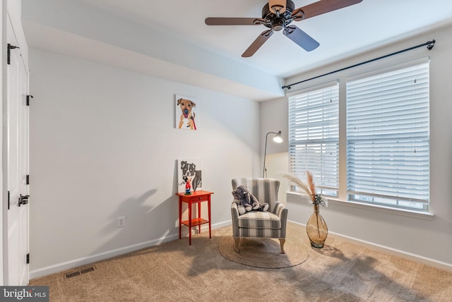 living area with carpet floors and ceiling fan