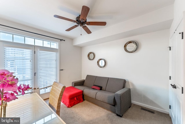 carpeted living room with a wealth of natural light and ceiling fan