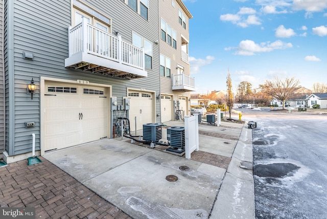 view of home's exterior with cooling unit, a garage, and a balcony