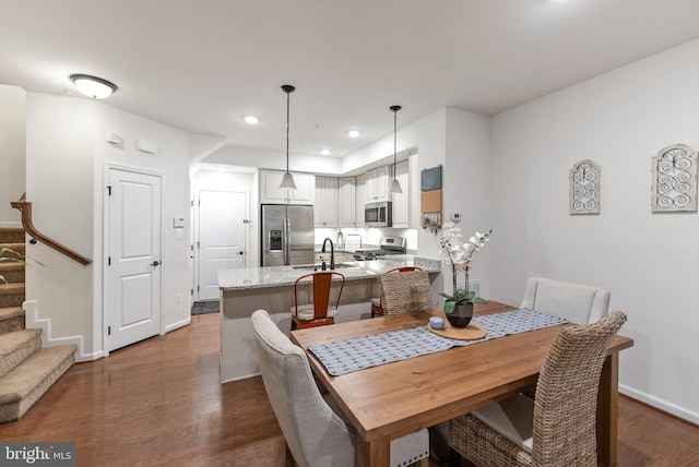 dining area featuring sink and dark hardwood / wood-style floors