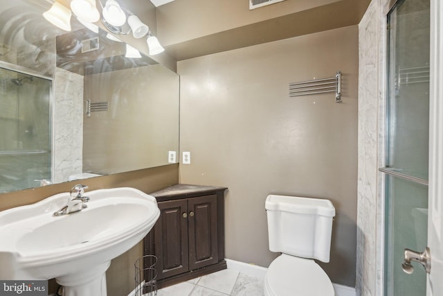 bathroom featuring sink, a shower with shower door, and toilet