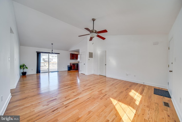 unfurnished living room with ceiling fan with notable chandelier, high vaulted ceiling, and light wood-type flooring