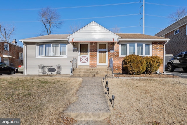 bungalow-style home with a front lawn