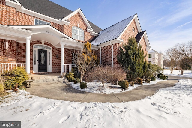 snow covered property featuring a porch