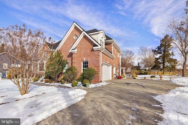 snow covered property with a garage