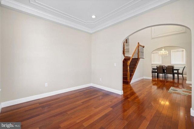 unfurnished room with dark hardwood / wood-style flooring, ornamental molding, and a chandelier