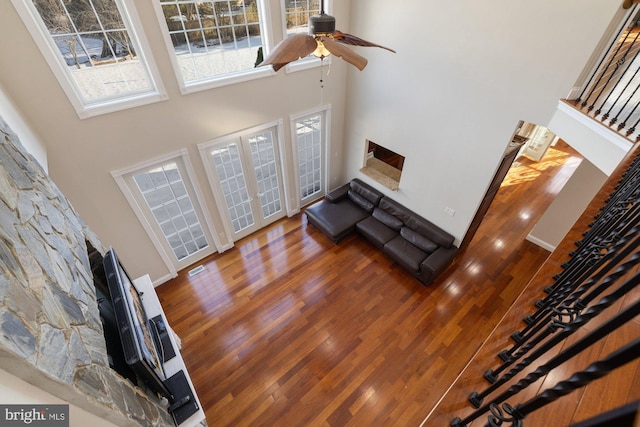 living room with french doors, a towering ceiling, dark hardwood / wood-style flooring, and ceiling fan