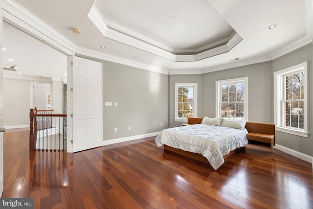 bedroom featuring crown molding, dark hardwood / wood-style floors, and a tray ceiling