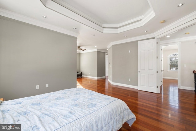 bedroom featuring a raised ceiling, ornamental molding, and dark wood-type flooring