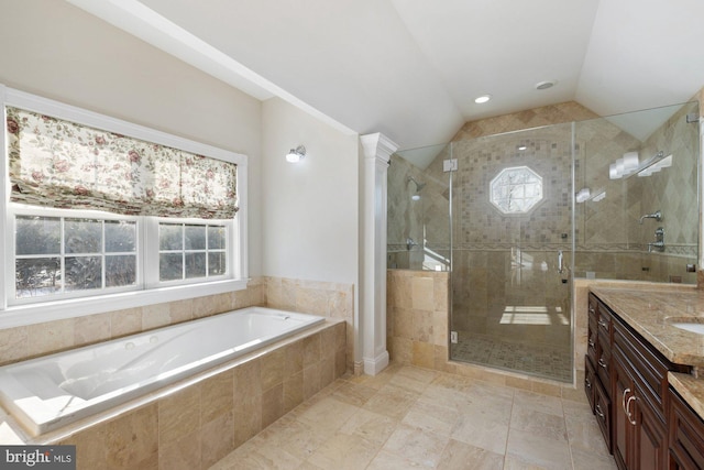 bathroom with a healthy amount of sunlight, plus walk in shower, vaulted ceiling, and vanity