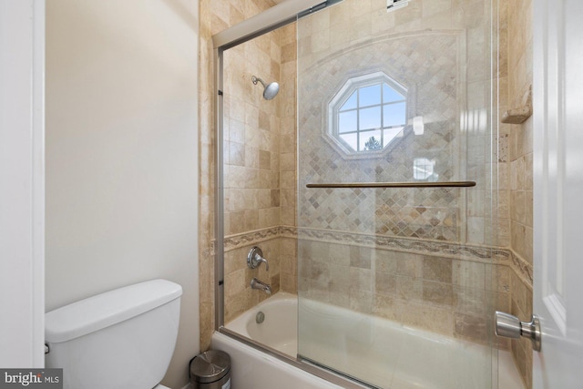 bathroom with bath / shower combo with glass door and toilet