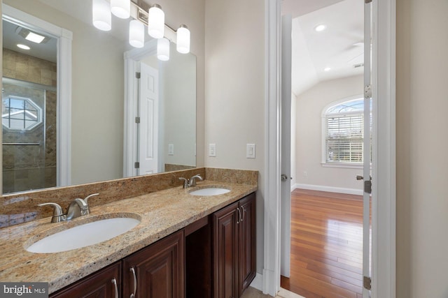 bathroom with vanity, hardwood / wood-style flooring, and lofted ceiling