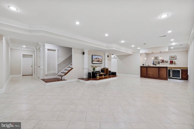 basement with wine cooler, indoor bar, crown molding, and light tile patterned floors