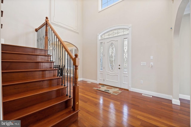 entrance foyer with hardwood / wood-style flooring and a high ceiling