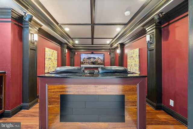 cinema room with ornamental molding, coffered ceiling, and hardwood / wood-style floors