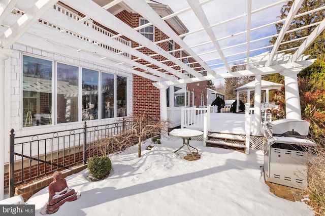 snow covered patio featuring a pergola