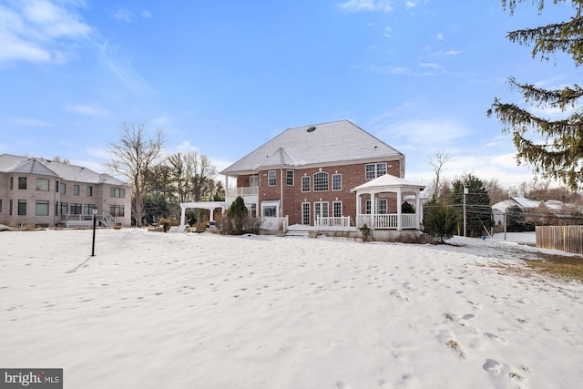 snow covered rear of property featuring a gazebo