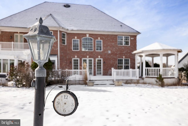 snow covered house featuring a gazebo