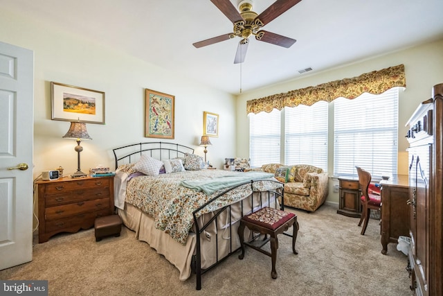 bedroom featuring visible vents, light colored carpet, and a ceiling fan