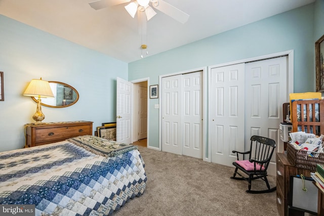 bedroom featuring two closets, a ceiling fan, and carpet floors