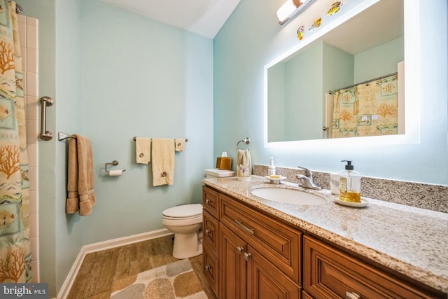 bathroom featuring toilet, curtained shower, wood finished floors, baseboards, and vanity