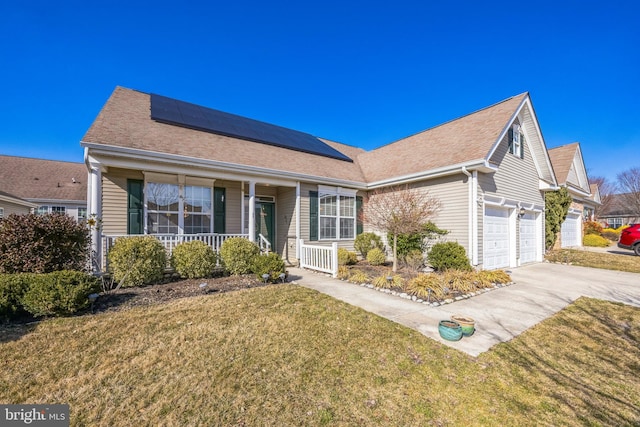 ranch-style house featuring driveway, roof mounted solar panels, a porch, a front yard, and a garage