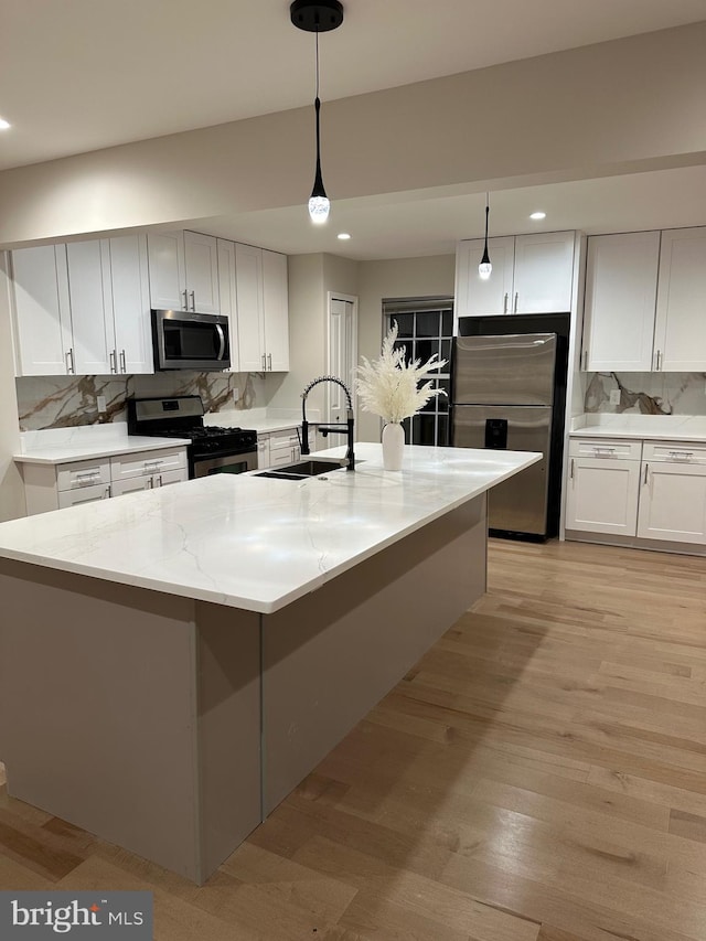 kitchen featuring pendant lighting, sink, white cabinetry, and stainless steel appliances